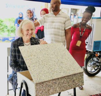 The US Ambassador looking at a desk made from recycled materials